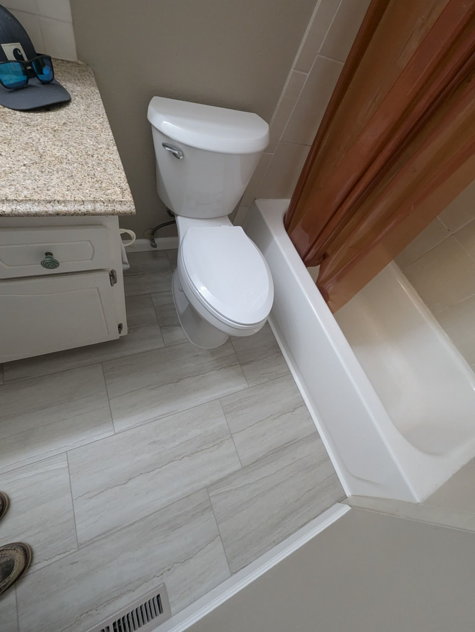 Finished bathroom after the Loveland job, with a new tile floor, restored toilet, and tub